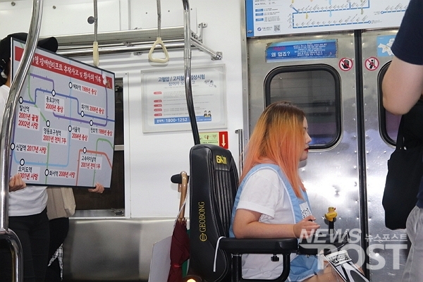 지난 21일 전국 장애인 차별철폐연대 회원이 시청역 지하철에서 휠체어 리프트 사고의 경각심을 알리는 피켓을 들고 있다. (사진=이별님 기자)