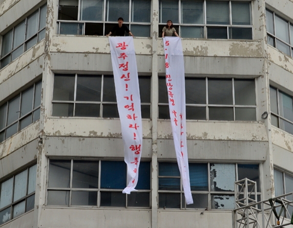 지난해 5월 17일 5·18 당시 헬기 사격이 자행됐던 광주 동구 금남로 전일빌딩에서 배우들이 38년 전 시위 모습을 재현하고 있다. (사진=뉴시스)