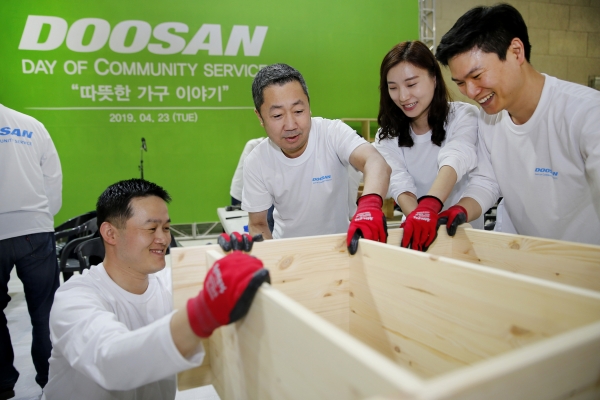 박정원 두산그룹 회장(가운데)이 임직원들과 함께 인근 지역 가정에 전달할 가구를 제작하고 있다(사진=두산그룹)