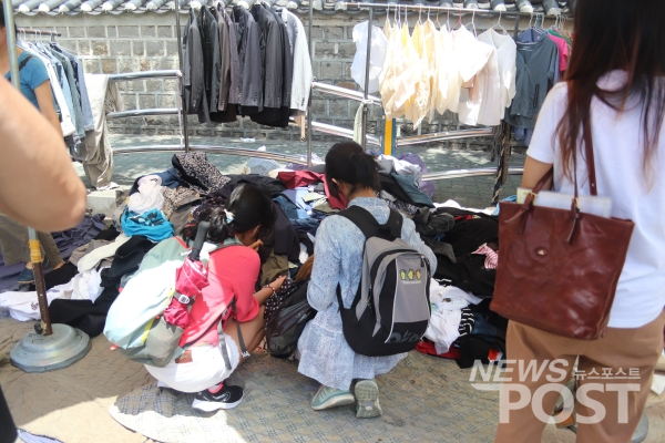 청년들이 '옷 무덤'이라 불리는 구제 옷 더미를 뒤져 옷을 고르고 있다(사진=김혜선 기자)