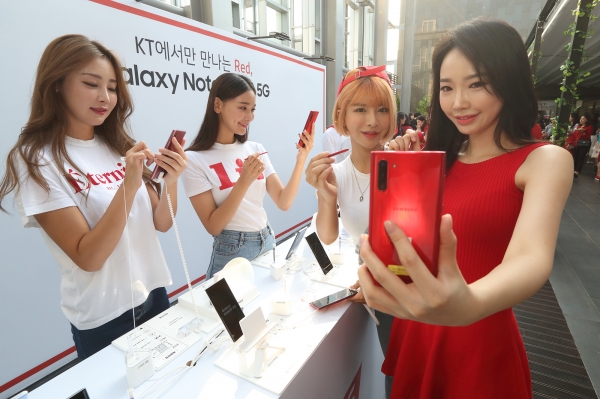 19일 노보텔 앰배서더 서울 동대문에서 열린 ‘갤럭시 노트10 5G’ 출시 기념 론칭 파티에서 모델들이 KT 전용 ‘아우라 레드’ 색상의 갤럭시 노트10 5G를 보고 있다. (사진=KT)