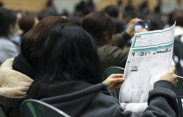 지난 17일 유웨이 ‘2020 정시 가채점 입시 전략 설명회’를 찾은 수험생과 학부모가 서울 동대문구 한국외국어대학교 오바마홀에서 배치표를 살펴보고 있다. (사진=뉴시스)