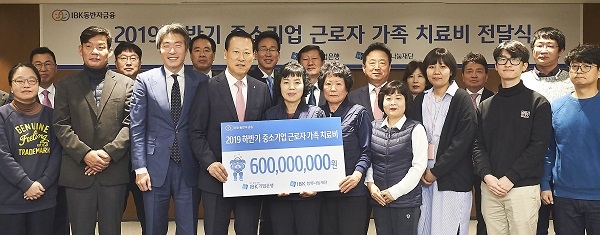 9일 을지로 기업은행 본점에서 김도진 은행장(앞줄 왼쪽 네 번째)과 중소기업 근로자 가족들이 치료비 전달식을 마치고 기념촬영을 하고 있다. (사진=IBK기업은행)