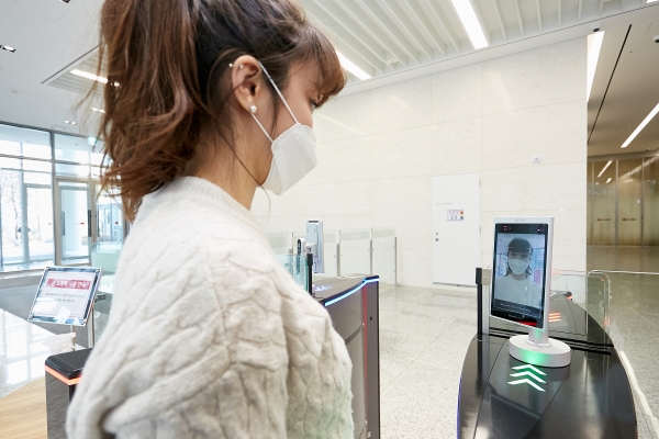 LG CNS 본사 출입게이트에서 직원이 얼굴인식 출입통제 단말기에 얼굴을 인식하는 모습. 마스크를 쓰더라도 AI를 통해 인식이 가능하다. (사진=LG CNS)