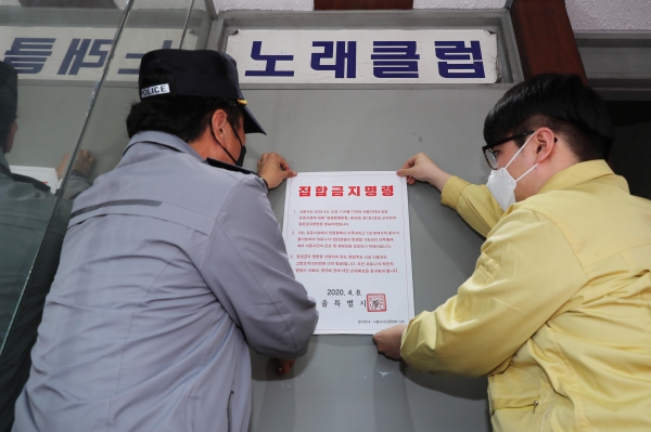 9일 서울 성동구 보건소 관계자와 경찰이 송정동 유흥업소에 집합금지 명령서를 붙이고 있다. (사진=성동구 제공)