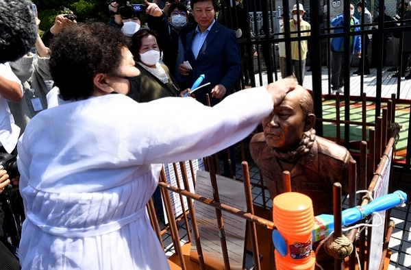 27일 광주 동구 광주지방법원 인근에 설치된 무릎 꿇은 전두환 동상에 5월 어머니회 회원이 응징을 가하고 있다. (사진=뉴시스)