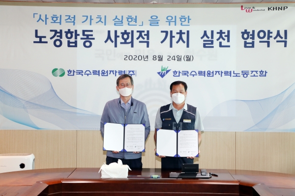 한국수력원자력 노사대표가 24일 코로나19로 침체된 지역사회 소비 활성화를 위해 ‘노경합동 사회적 가치 실천 협약’을 체결했다. 정재훈 한수원 사장(왼쪽)과 노희철 노조위원장(오른쪽)이 기념촬영을 하고 있다. (사진=한국수력원자력 제공)