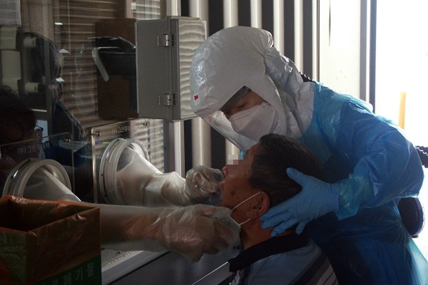 김윤 강원대학교병원 간호조무사가 워킹 쓰루 선별 진료소에서 코로나19 검체 체취를 돕고 있다. (사진=김윤 강원대학교병원 간호조무사 제공)