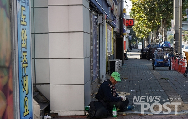 서울 영등포 쪽방촌 앞 한 노숙인이 막걸리를 마시며 앉아있다. (사진=뉴스포스트 이해리 기자)