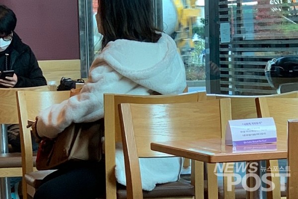 13일 마스크 의무화 행정 명령 첫날 서울 송파구의 한 프랜차이즈 커피 전문점에서  시민들이 코로나19 감염 확산 방지 및 예방을 위해 마스크를 착용했다. 테이블에는 사회적 거리두기 지침을 준수하라는 안내표가 세워져 있다. (사진=뉴스포스트 이별님 기자)