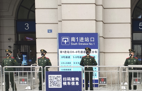 폐렴사태로 봉쇄령이 내려진 지난해 1월 23일 중국 후베이성 우한시에서 경찰들이 폐쇄된 기차역 앞을 지키고 있다. (사진=AP/뉴시스)