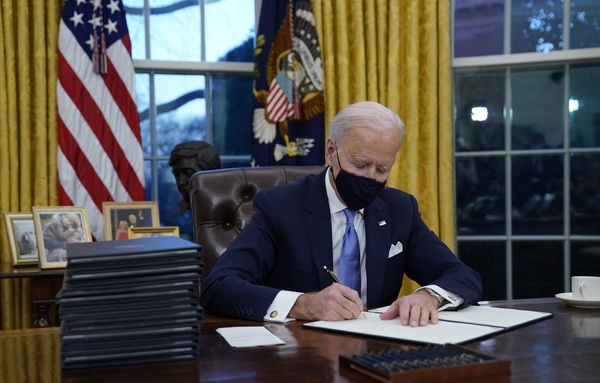 21일(한국 시간) 조 바이든 미국 대통령이 백악관 오벌오피스에서 첫 행정명령에 서명하고 있다. (사진=AP/뉴시스)