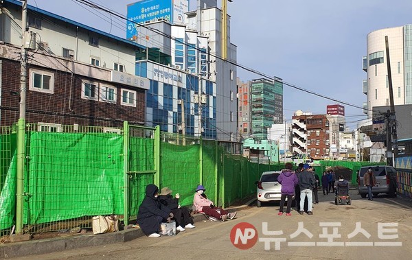 쪽방촌 주민과 노숙인들이 간식을 받기 위해 줄을 서 있다. 줄은 쪽방촌 초입부터 50m가량 이어졌다.  (사진=뉴스포스트 이해리 기자)