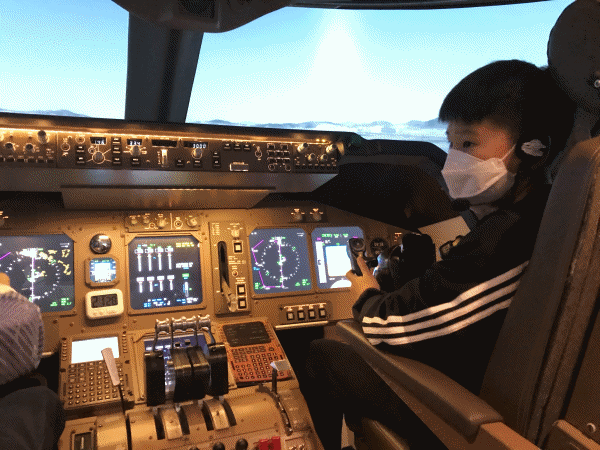 김우식 강사와 함께 시뮬레이터로 보잉 항공기를 이착륙해보는 최정원 군. (사진·편집=뉴스포스트 이상진 기자)