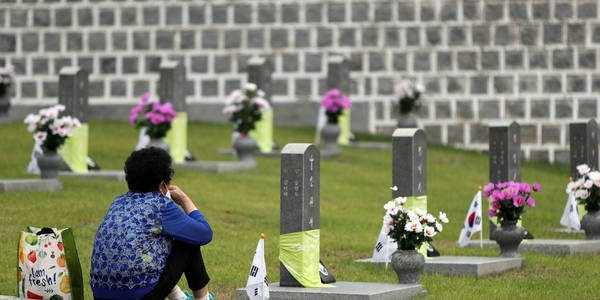 18일 오전 광주 북구 국립 5·18 민주묘지에서 한 열사의 어머니가 묘지 앞에 앉아있다. (사진=뉴시스)
