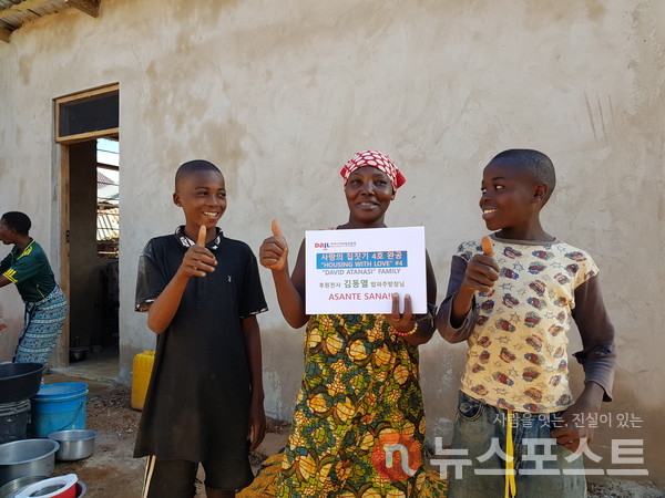 아프리카 현지 수혜자 가족이 김동열 기관사가 기부한 집 앞에서 기념 사진을 찍고 있다. (사진=밥퍼나눔운동본부 제공)