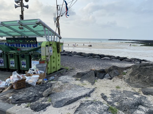 해변가 분리수거장 앞에 쓰레기가 쌓여있다.(사진=조유라)