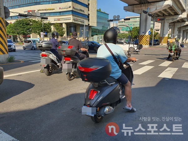 정지선을 넘은 채 신호 대기 중인 배달원들. (사진=뉴스포스트 이해리 기자)