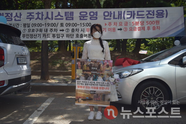 부케와 피켓을 든 예비 신부가 1인 시위를 진행하고 있다. (사진=뉴스포스트 홍여정 기자)