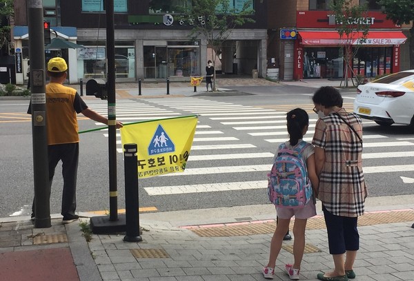 송파구 한 초등학교 인근 횡단보도 앞에서 초등학생 아이와 조부모가 신호를 기다리고 있다. (사진=뉴스포스트 이해리 기자)