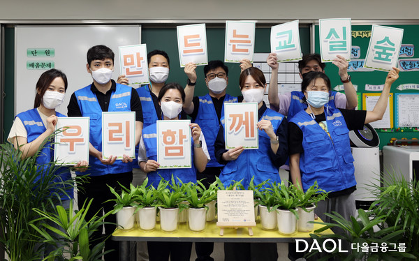 다올금융그룹 봉사단 ‘밝은내일 서포터즈’가 지난 15일 수원 신성초등학교에서 ‘교실 숲’ 조성을 위한 공기정화식물을 전달하고 기념촬영을 하고 있다. (사진=다올금융그룹)