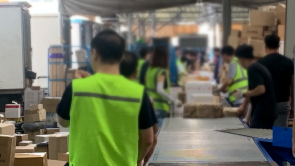 오전7시 분류작업이 시작되면서 분류도우미와 택배기사들이 컨베이어벨트 앞에 서있다.(사진=이병우기자)