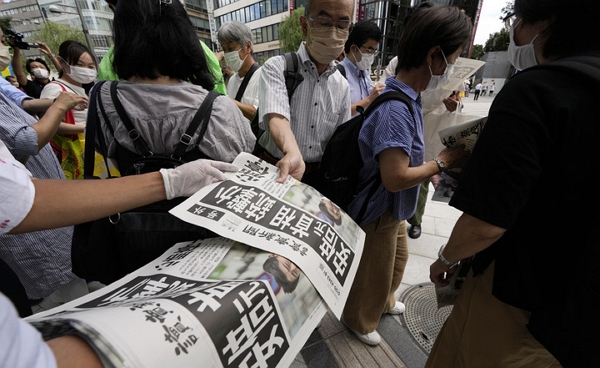 지난 7월 8일 일본 도쿄에서 요미우리 신문사 직원들이 아베 신조 전 총리의 피격 소식을 전하는 호외판을 배포하고 있다. (사진=AP/뉴시스)