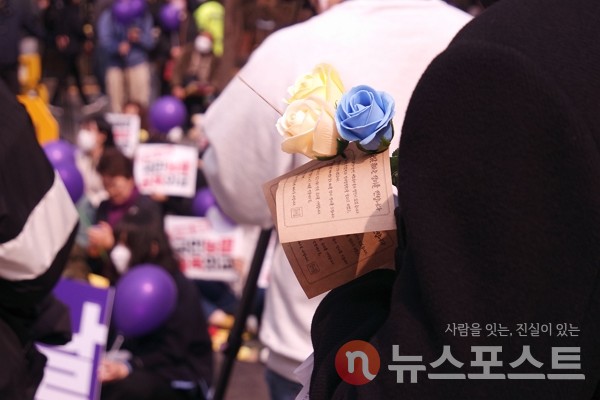 8일 서울 종로구 일대에서 한 시민이 한국여성의전화 관계자들이 나눠 준 장미꽃을 들고 있다. (사진=뉴스포스트 이별님 기자)