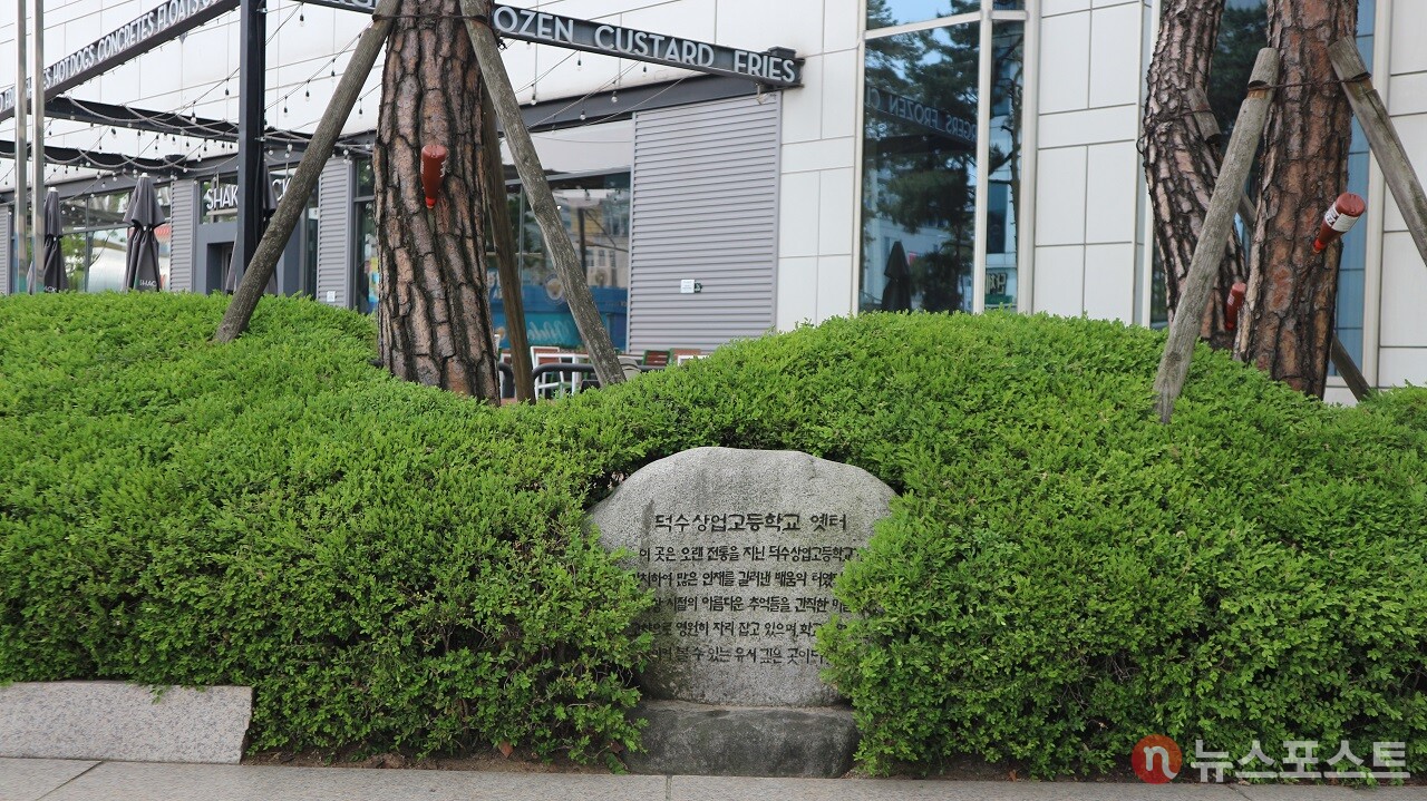 두타몰 입구 화단에 있는 '덕수상업고등학교 옛터' 표지석. (사진=뉴스포스트 강대호 기자)