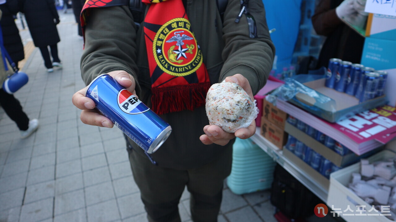 (2024년 12월 14일) 여의도 춧불집회에서 주먹밥과 음료수를 나눠주는 시민. 2024년 겨울 시민들에 의해 열린 광장은 공론장이면서 연대의 장이 되고 있다. (사진=뉴스포스트 강대호 기자)