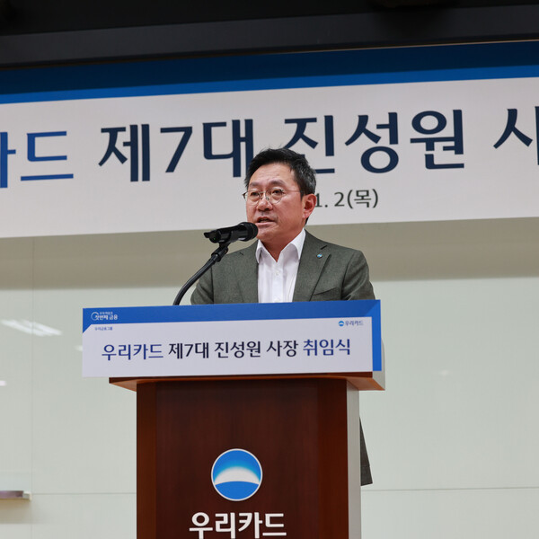 이달 2일 광화문 본사에서 진행된 우리카드 신임 사장 취임식에서 진성원 사장(가운데)이 직원 대표 2명에게 사원증과 꽃다발을 받고 기념사진을 촬영하고 있다. (사진=우리카드)