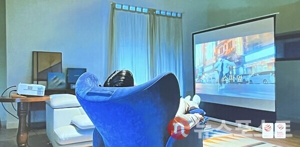 바디프랜드의 새 브랜드 '파밀레' 홍보 영상에서 한 남성이 제품에 누운 채 TV를 시청하는 모습이다. (사진=뉴스포스트 최문수 기자)