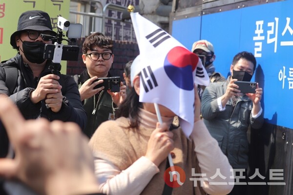 4일 서울 종로구 헌법재판소 일대에서 윤석열 전 대통령 지지자가 태극기로 얼굴을 감싸며 오열하고 있다. (사진=뉴스포스트 이별님 기자)