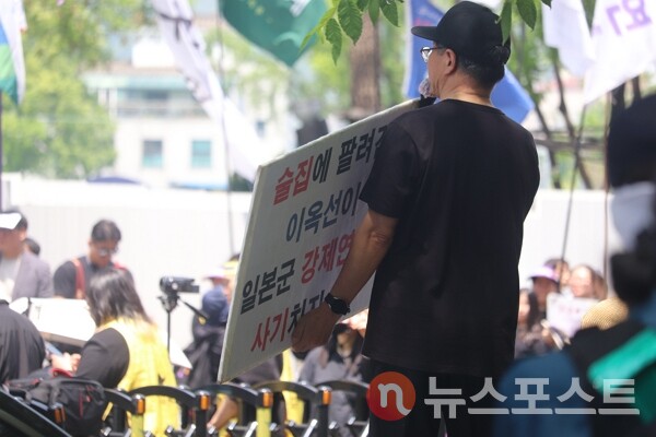 14일 오후 12시 정의기억연대가 주최한 '제1700차 일본군성노예제 문제해결을 위한 정기 수요시위' 장소 옆에서 한 남성이 고(故) 이옥선 할머니의 일본군 '위안부' 피해 사실을 부정하는 내용의 피켓을 들었다.