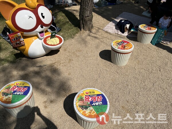 너구리 캐릭터가 너구리 라면을 들고 있다. 옆에는 육개장과 김치 사발면 모양의 의자가 보인다. (사진=김윤진 기자)