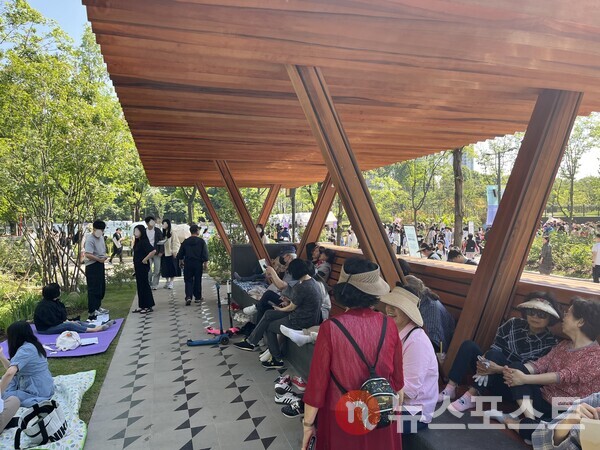 어르신들이 지붕 아래에서 더위를 피하고 있다. (사진=김윤진 기자)