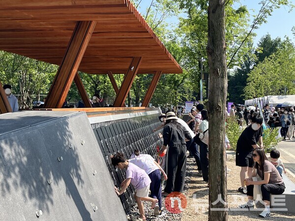 정원의 온도에 마련된 워터 월. 아이들이 손과 발을 대며 열을 식히고 있다. (사진=김윤진 기자)