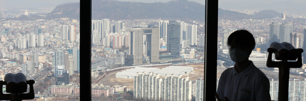 서울 영등포구 63스퀘어 빌딩에서 한 방문객이 아파트 단지를 바라보고 있다. (사진=뉴시스)