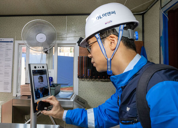 DL이앤씨 소속 한 근로자가 안전 삐삐를 지급받은 후 안면인식 시스템을 거쳐 현장에 출입하고 있다. (사진=DL이앤씨)