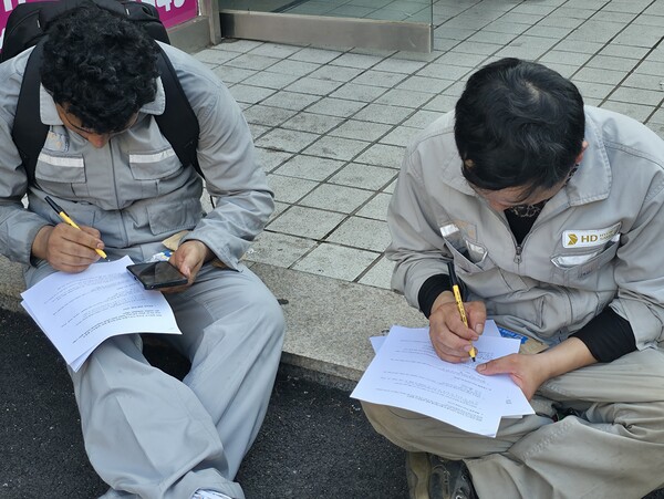 바닥에 앉아 설문조사에  답하고 있는 이주노동자들. (사진=뉴스포스트 최종원 기자)