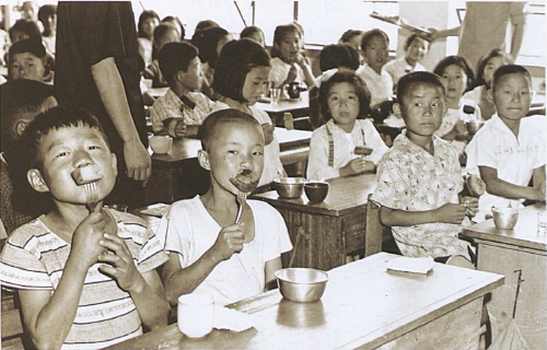1964년 우유와 옥수수 가루로 만든 빵을 먹는 응암국민학교 학생들을 촬영한 사진.