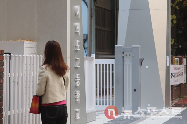 13일 2026학년도 대학수학능력시험이 치러지는 서울 영등포구 여의도 고등학교에서 한 시민이 발걸음을 떼지 못하고 있다. ('사진=뉴스포스트 이별님 기자)