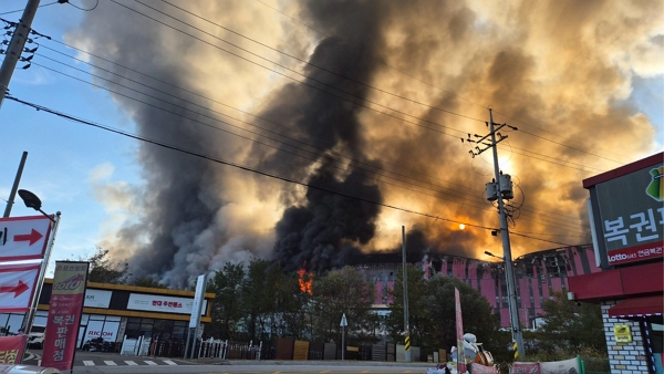 15일 오전 충청남도 천안시 동남구 풍세면 이랜드패션 물류센터에서 불이나 검은 연기가 치솟고 있다. (사진=독자 제공)